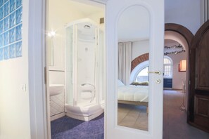 Une salle de bain moderne avec une douche à parois de verre, des toilettes blanches et un sol carrelé de bleu.