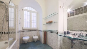 A bathroom with a glass sink, two toilets, a bidet, and a shower. - Duomo Deluxe Apartment (Firenze)