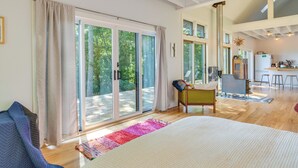 Une pièce spacieuse avec un grand lit, une chaise et une vue sur un balcon.