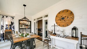 A dining area with a wooden table, black chairs, and a large wooden clock on the wall. - Waterfront Vacation Property on the Pamlico (Bath)