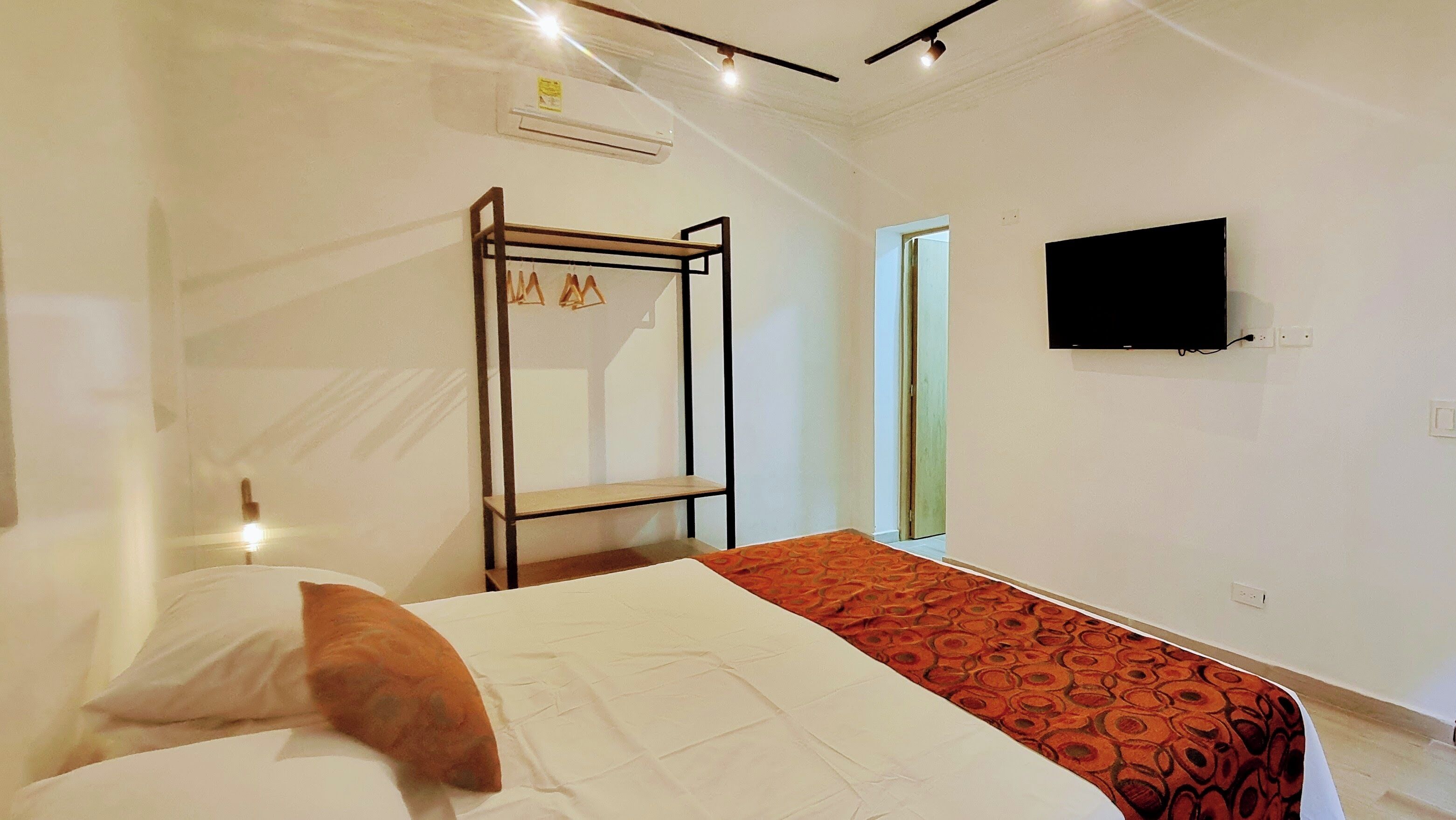 A bedroom with a bunk bed, a flat-screen TV mounted on the wall, and a window with a view.