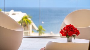 A balcony with a view of the sea, two white chairs, and a vase with red flowers. - Florida Sun : Beautiful appartment with sea view (Schoelcher)