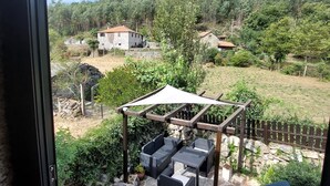 En uteplats med utemöbler, en pergola och ett stengolv.