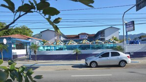 A hotel with a reception area, a covered outdoor seating area, and a view of the mountains. - No property  (Centro Caraguatatuba)