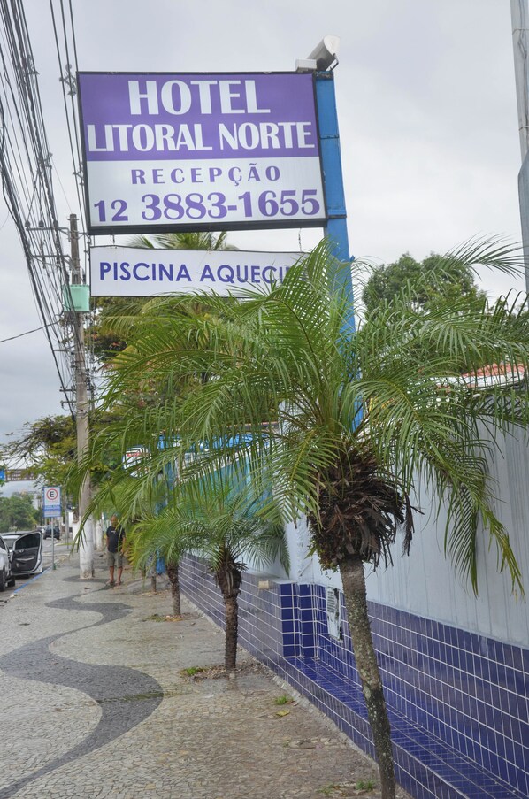 A hotel sign with reception and contact number.