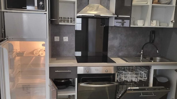 A modern kitchen with built-in appliances including a microwave, oven, and dishwasher. - Appartement Proche de Vernon Giverny (Vernon)