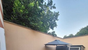 Un patio exterior con un conjunto de sofás, una mesa y una zona cubierta.