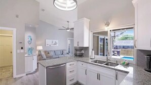 A modern kitchen with white cabinets, granite countertops, and a built-in dishwasher. - Tropical Vacation Home Marco Island Florida - Close to Beaches-Pet Friendly-POOL (Marco Island)
