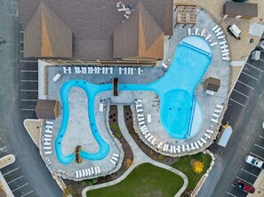 An aerial view of a swimming pool complex with multiple pools and a surrounding road. - Near Indoor & Outdoor Pools: Hot Tub, Game Room & Free Silver Dollar City Tickets (Kimberling City)