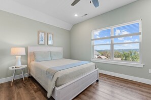 A bedroom with a bed, a nightstand, a lamp, a window with a view, and a ceiling fan. - Near Indoor & Outdoor Pools: Hot Tub, Game Room & Free Silver Dollar City Tickets (Kimberling City)