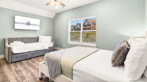 Une chambre comprenant un lit, un canapé-lit, un ventilateur de plafond, une fenêtre avec vue et un panneau fixé au mur.
