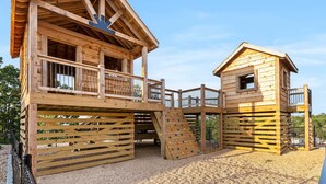Une cabane en bois pour enfants, avec un toboggan et une petite fenêtre.
