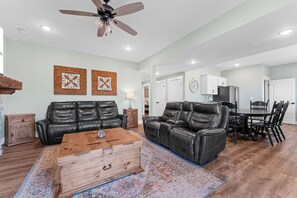 A spacious living room with a leather sofa, a wooden coffee table, and a ceiling fan. - Near Indoor & Outdoor Pools: Hot Tub, Game Room & Free Silver Dollar City Tickets (Kimberling City)