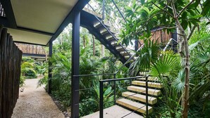A staircase surrounded by lush greenery, leading to a covered area with a view of the surrounding vegetation. - Dhalia -Private roof with pool & Beach Club Access (Tulum)