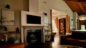 A spacious living room with a fireplace, leather sofas, and a wooden ceiling. - TuscanyNTexas (La Grange)