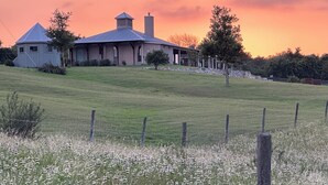A house with a large lawn and a fence in the foreground. - TuscanyNTexas (La Grange)