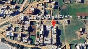 Vue aérienne de Dar Attia Ez Zahra, avec une disposition côtière comprenant des bâtiments, des espaces verts et une plage.