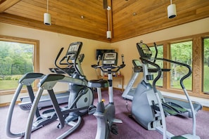 A gym with three elliptical machines, a treadmill, and a stationary bike.
