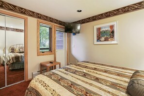 Rest and Recharge - This comfortable bedroom features a cozy bed, TV, and private outdoor access for an added touch of convenience.