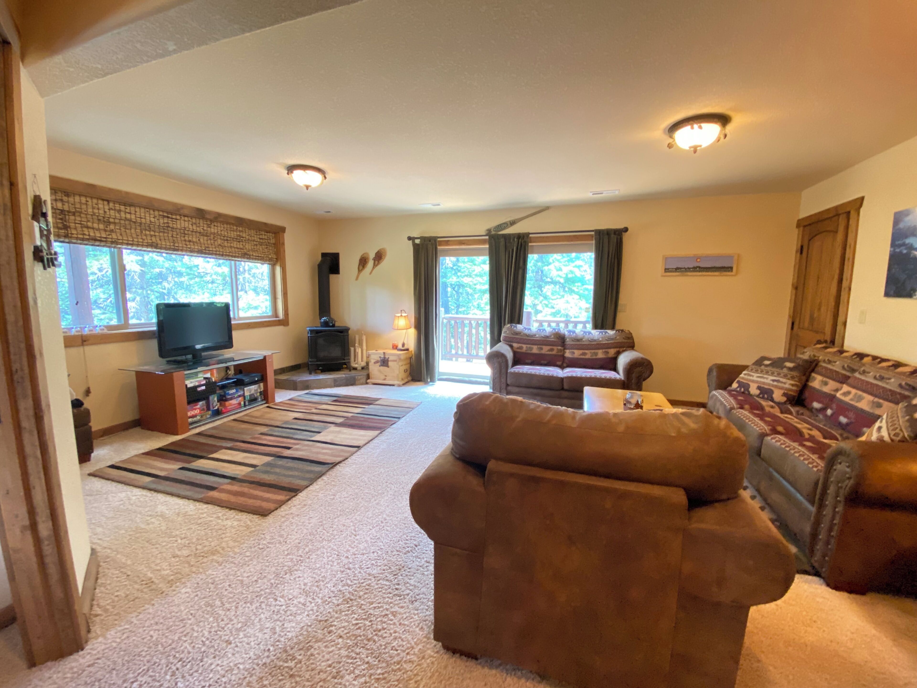 A cozy living room with a fireplace, a television, and a sofa.