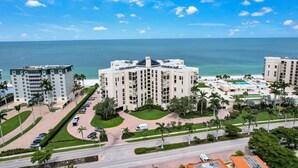 A high-rise hotel with multiple floors, a swimming pool, and a view of the ocean. - Beachfront delight in the Moorings! (Naples)