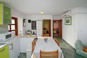 A compact kitchen with a microwave, refrigerator, and dining table.