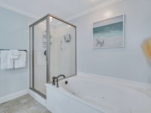 Een bad/douchecombinatie, een haardroger, handdoeken