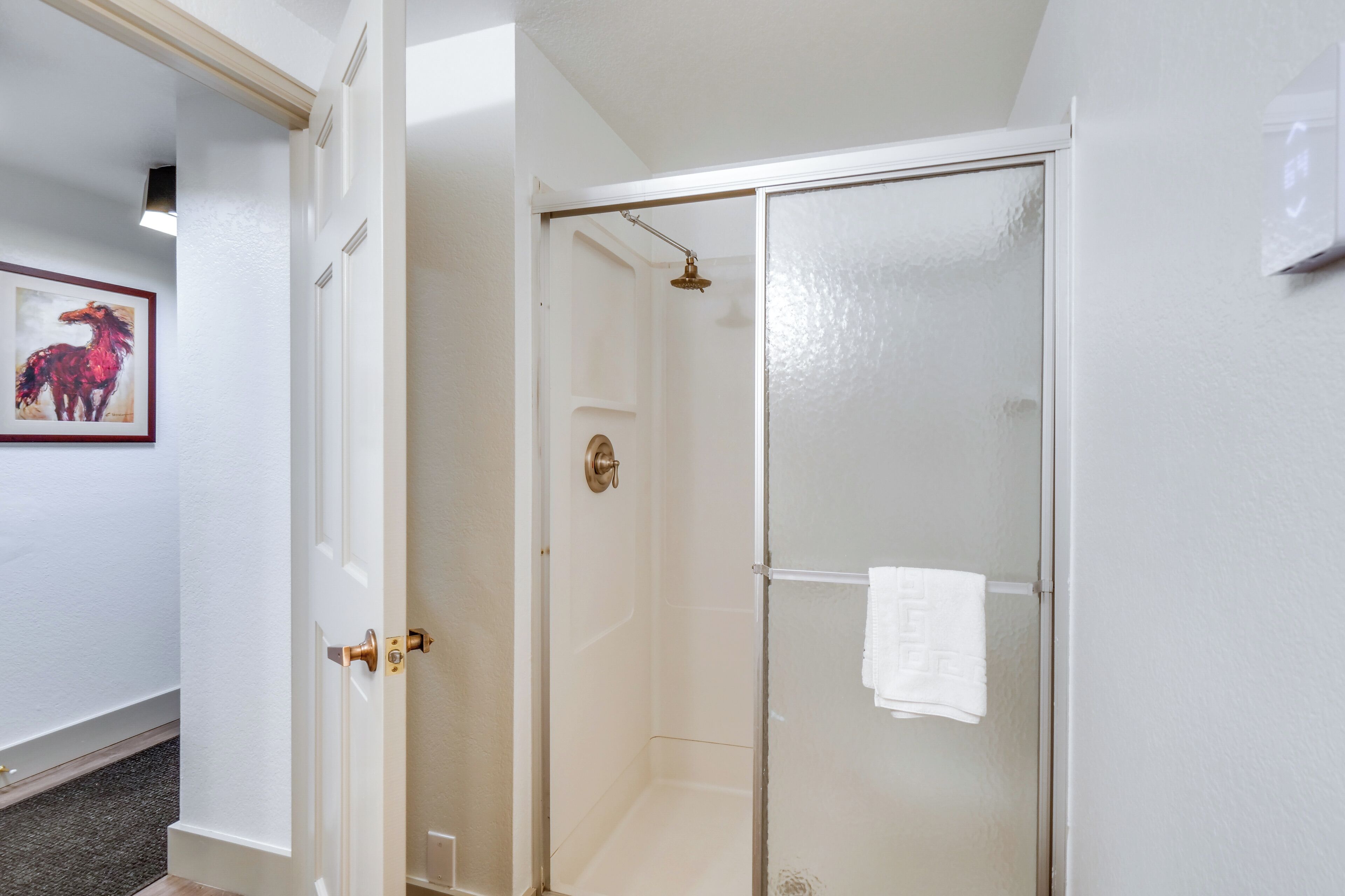 A glass-enclosed shower with a towel hanging on the door.