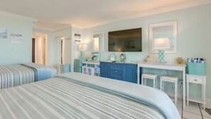 A bedroom with two beds, a dresser, a vanity with a mirror, and a desk with two chairs. - Daytona Beach Studio w/ Ocean View + Amenities! (Daytona Beach)