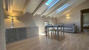 A modern, open-plan living space with a dining area, sofa, and skylight.