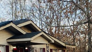 A house with a large red bow on the front door, a sign reading "208 Cozy Cottage Mt. Pleasant Road". - Cozy Cottage in the country,  Pet Friendly. 2.8 mil from Tupelo Furniture Market (Tupelo)