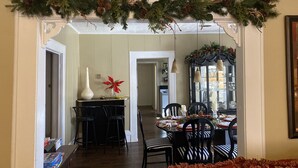 A dining area with a Christmas garland, a tall white vase, and a red poinsettia. - Cozy Cottage in the country,  Pet Friendly. 2.8 mil from Tupelo Furniture Market (Tupelo)