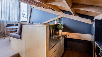 A compact kitchen with wooden cabinetry, a built-in sink, and a small countertop.