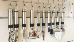 A wall-mounted rack holding various kitchen utensils.