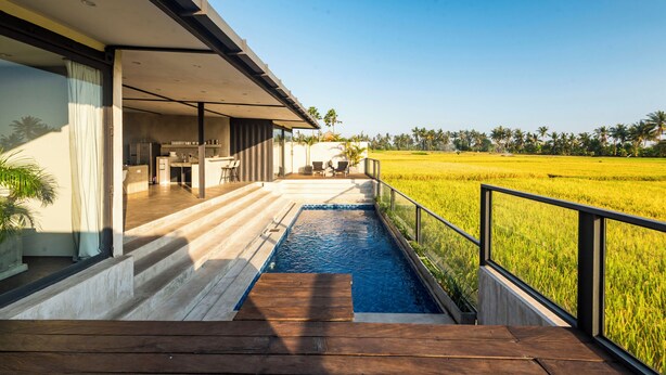 A modern house with a swimming pool, a patio, and a view of a rice field. - Joshua District (Tabanan)