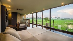 A spacious room with a large window offering a view of a green landscape. - Joshua District (Tabanan)