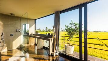 Enjoy a serene bathroom retreat with a large mirror, glass-enclosed shower, and sink, plus an outdoor space with a lush view.