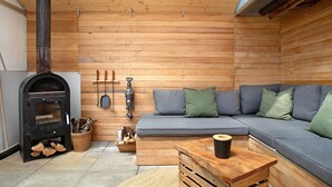 Une pièce chaleureuse avec une cheminée, un canapé et une table basse.