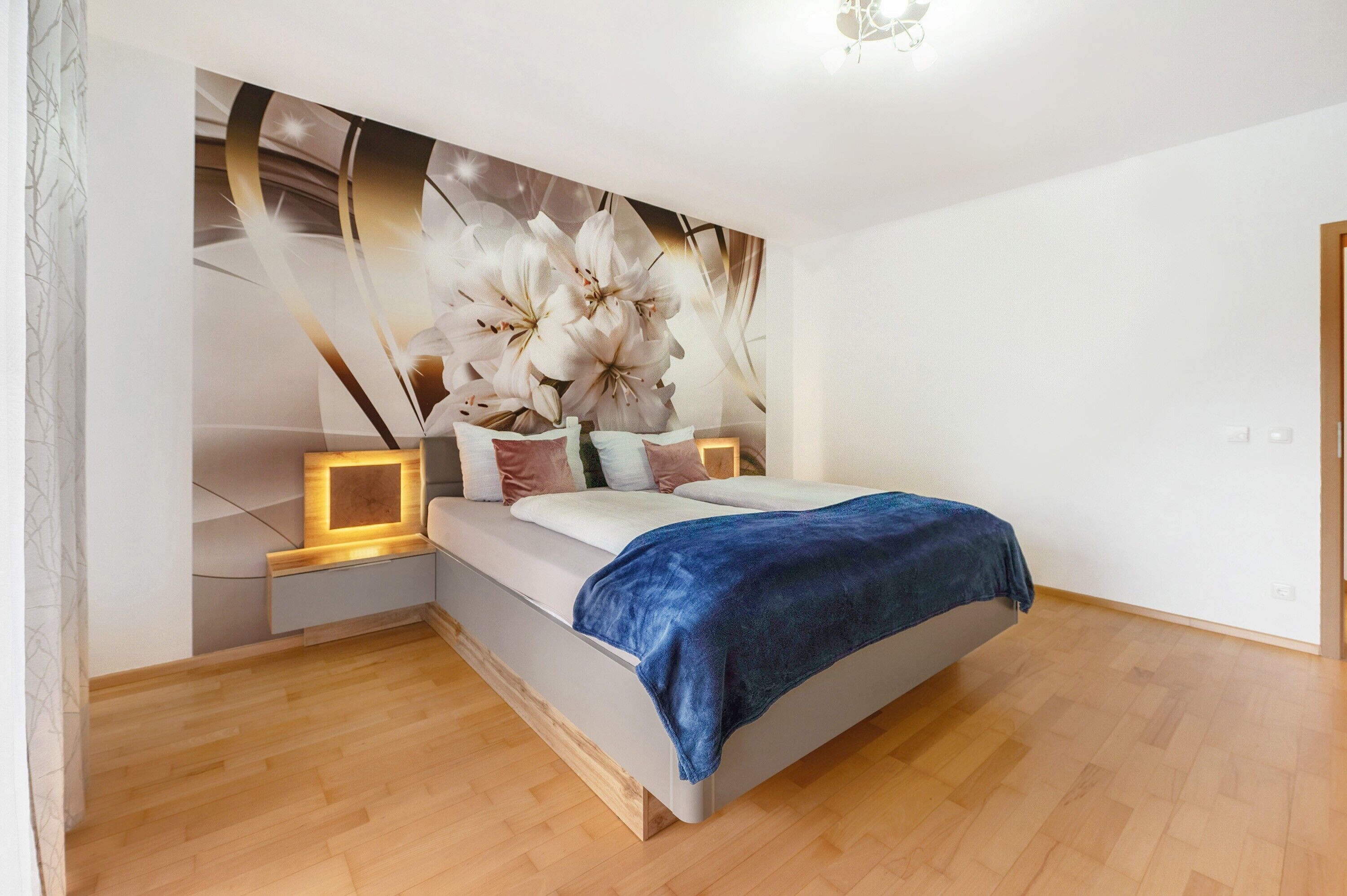 Une chambre à coucher comprenant un lit, des tables de chevet, une lampe fixée au mur et un élément décoratif mural.
