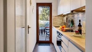 A narrow kitchen with a view to an outdoor seating area. - Apartment 'Oskar' with Garden View, 2 Balconies and Wi-Fi (Titisee-Neustadt)