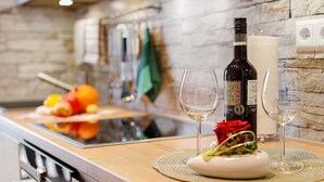 A kitchen counter with a bottle of wine, two glasses, and a plate with food. - Apartment 'Oskar' with Garden View, 2 Balconies and Wi-Fi (Titisee-Neustadt)