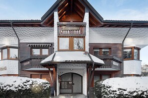 Ein mehrstöckiges Gebäude mit Holzfassade, einem Balkon und einem Schild, das es als Skigebiet kennzeichnet.