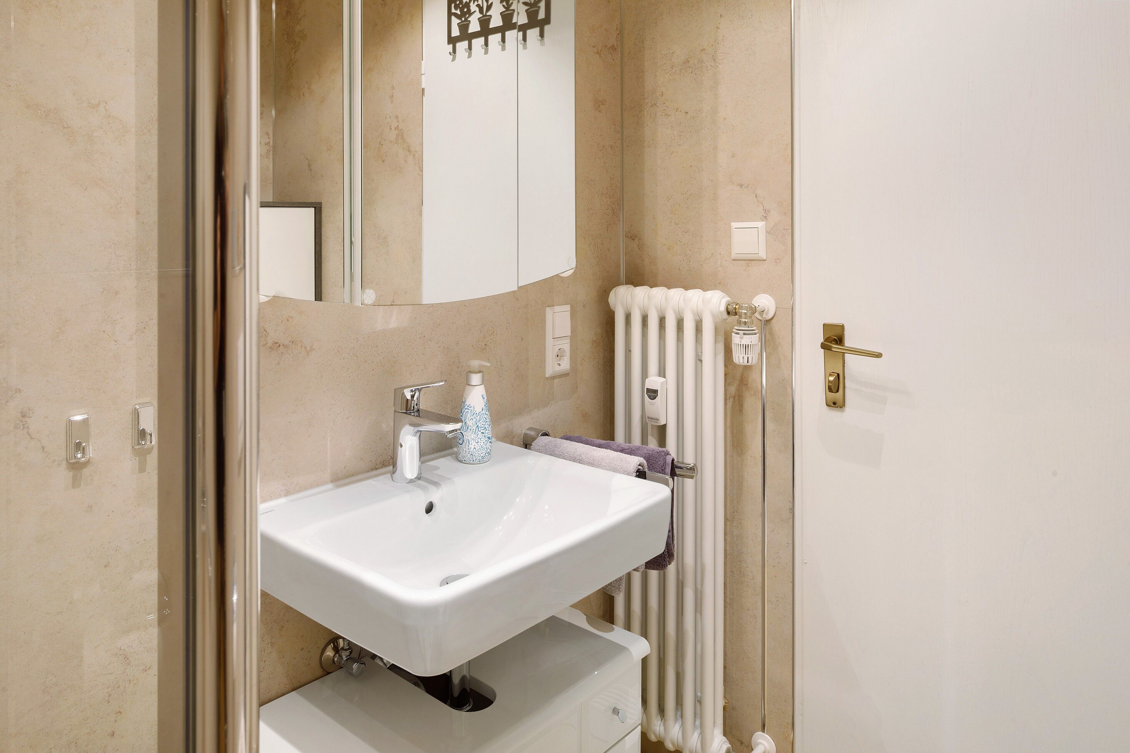 Ein Badezimmer mit Waschbecken, Spiegel und Handtuchhalter.