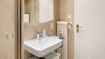 Ein Badezimmer mit Waschbecken, Spiegel und Handtuchhalter.