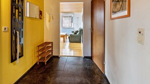 A hallway with a wooden door, a mirror, a rack, and a framed picture on the wall. - Holiday Apartment 'Eule' with Wi-Fi (Donaueschingen)