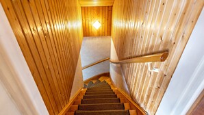 A wooden staircase with carpeted steps and a handrail, leading to a room with a wooden ceiling and a light fixture. - Holiday Apartment 'Eule' with Wi-Fi (Donaueschingen)