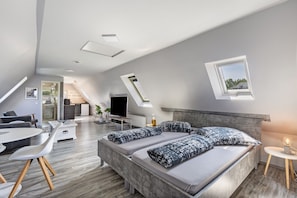 Une chambre de style loft moderne, dotée d’un grand lit, d’un bureau et d’un coin repas.