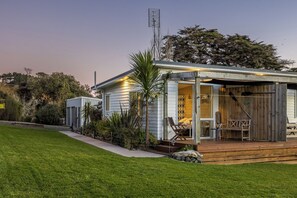 A single-story house with a covered porch, a small deck, and a fenced yard.