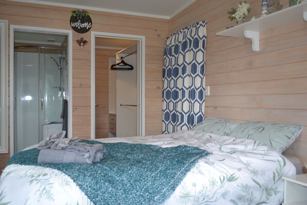 Un dormitorio con cama, ducha, armario y letrero de bienvenida.