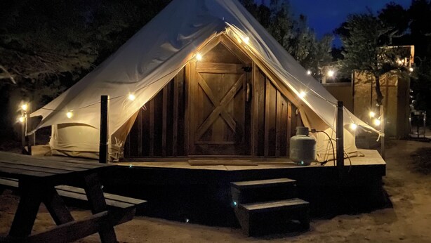 A tent with a wooden interior and a bench outside. - Catch your breath in the beauty of Hope Acres (Strawberry)